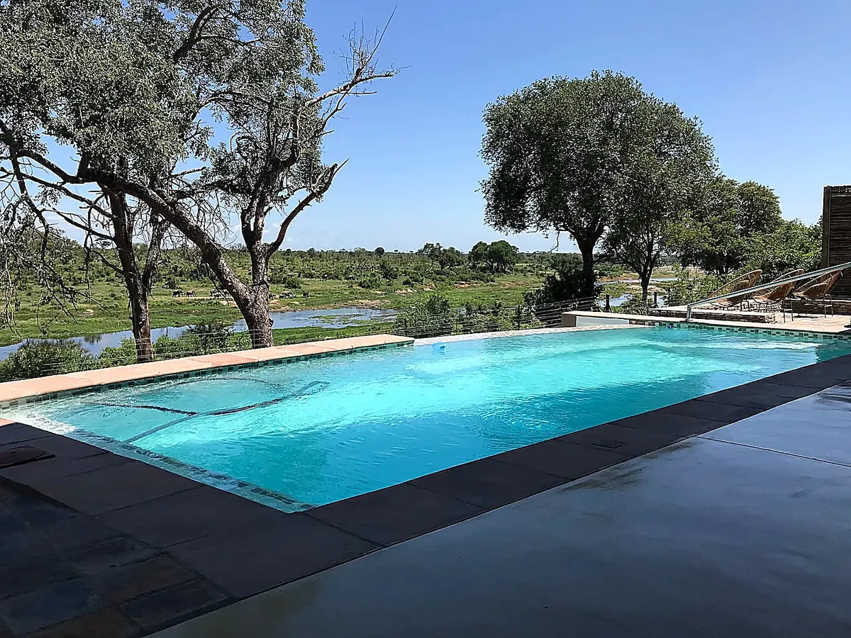Crystal clear infinity pool on a sunny day with river view