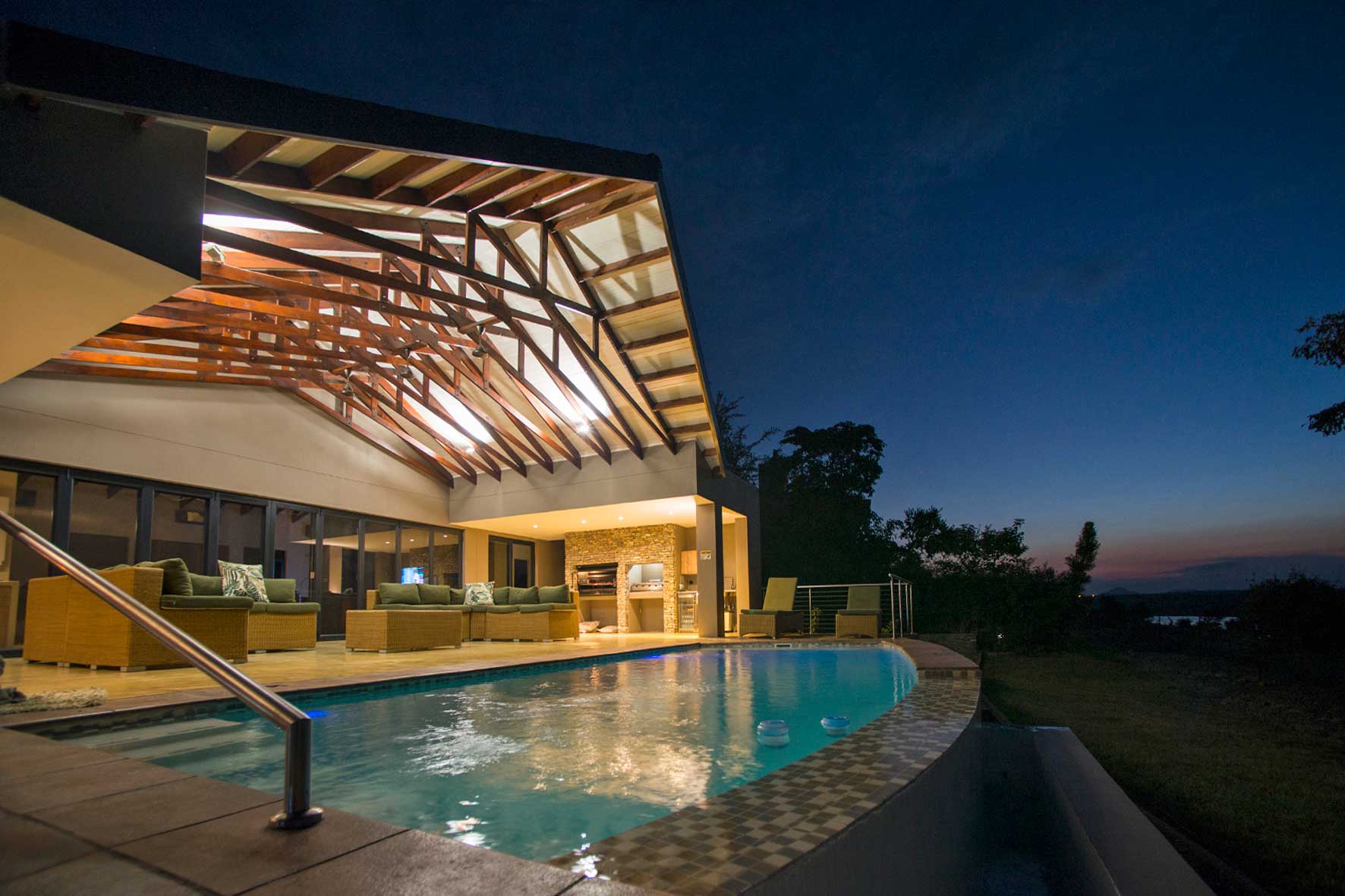 Lodge exterior at night with pool illuminated